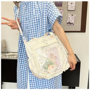 Detail of off-white tote bag featuring a clear PVC pocket and elegant ruffled edge design