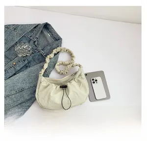 Detail view of the light green nylon crescent bag with drawstring and ruched strap