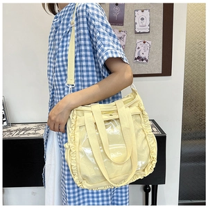 Detail view of the yellow ita bag with ruffled edges and large transparent PVC window