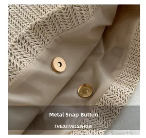 Gros plan du fermoir magnétique doré à l'intérieur d'un sac cabas tissé beige
