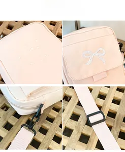 Detail of water-resistant fabric with bow embroidery and adjustable nylon strap on pink bag