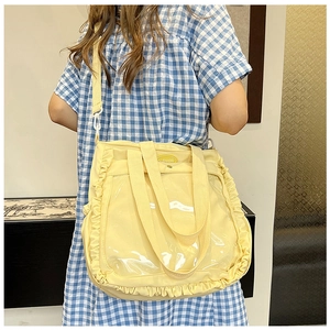 Detail of yellow tote bag with ruffle trim, transparent window and adjustable strap