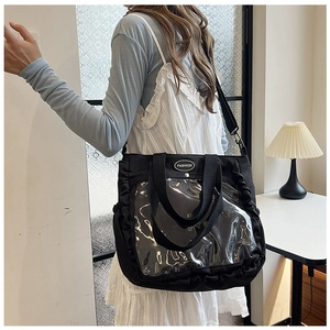 Detail of black canvas tote bag with transparent PVC pocket and ruffle edge trim