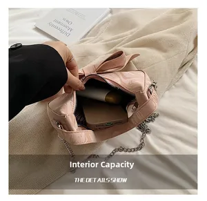 Internal capacity of pink bow handbag showing storage space for phone and essentials