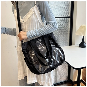 Detail of black tote bag with transparent PVC panel and ruffled edges for women