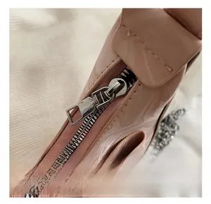 Close-up of premium metal zipper and glossy pink patent leather on stylish handbag