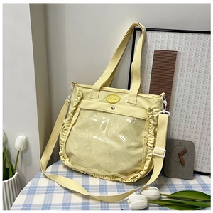 Detail view of the yellow canvas tote with ruffle trim and transparent PVC pocket