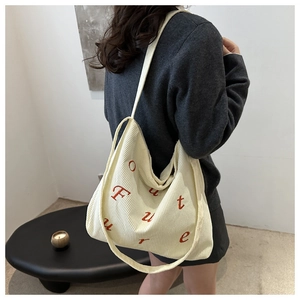 Detail view of corduroy tote bag with Future red letter print in minimalist setting
