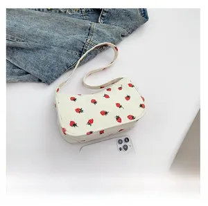 Détail du sac en velours côtelé blanc aux fraises rouges avec smartphone pour la taille