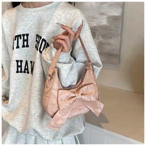 Close-up of pink bow handbag with marble texture surface and slim shoulder strap