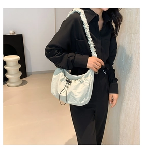 Detailed view of pale green drawstring nylon tote bag with wide ruched shoulder straps