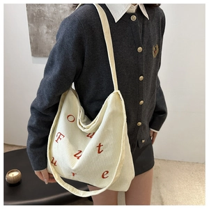 Detail view of cream corduroy tote bag showing large capacity and red Future embroidery