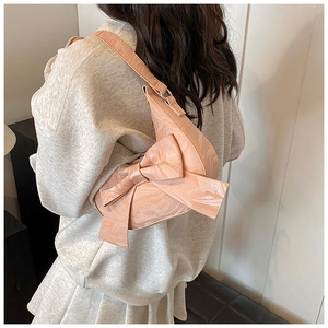 Detailed view of pink moon bag with large bow and marble texture worn on the shoulder