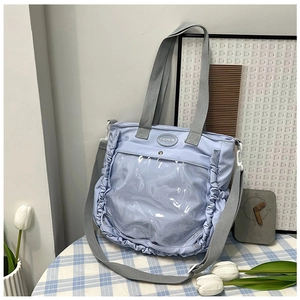 Detail of light blue ruffled tote bag with transparent PVC pocket and grey handles