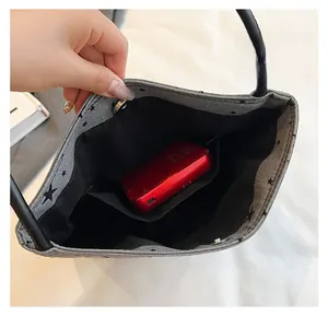 Detailed interior view of grey star patterned handbag with inner pocket and magnetic closure