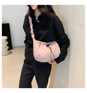 Detail of mauve nylon tote bag featuring drawstring closure and ruffled shoulder strap