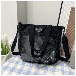 Detail of black ita bag showing clear PVC display pocket with side ruffle trim and straps