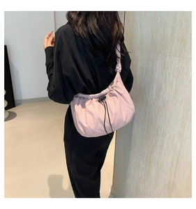Detail of light pink nylon tote bag showing drawstring closure and ruched fabric texture