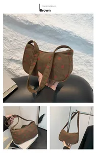 Détail du sac hobo en velours côtelé marron avec broderie fraise et zip métallique