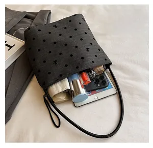 Top view of spacious grey polka dot bag interior containing tablet and umbrella