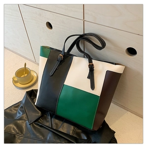 Close-up of color-block patchwork tote bag with adjustable metallic buckle straps