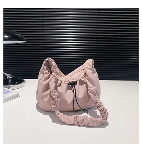 Detail of light pink drawstring nylon tote bag featuring cloud-like pleated texture