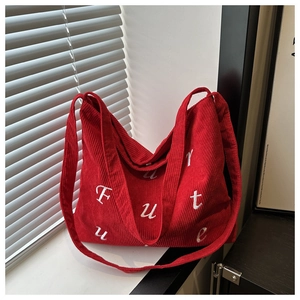 Detail of red corduroy tote bag showing ribbed texture and Future letter embroidery