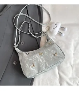 Detail of silver metallic butterfly tote bag with chain strap and plush cloud charm decor