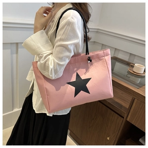 Detail of pink nylon tote bag featuring a black star design and drawstring closure