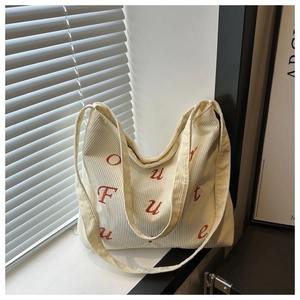 Detail of off-white corduroy tote bag with red embroidered Future text and ribbed texture