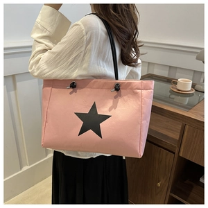 Pink nylon tote bag featuring black star print worn by model over shoulder