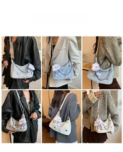 Detail view of crescent chain bag with silver butterfly accents and plush cloud charm
