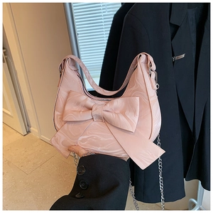 Detail of pink bow handbag featuring white marble texture and elegant silver chain strap