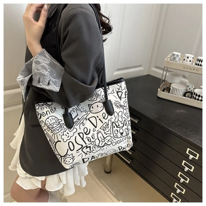 Detail of white graffiti tote bag with black straps and artistic hand-drawn sketches
