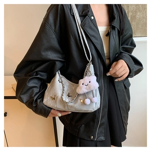 Detail of silver ruched tote bag with butterfly charms and a plush cloud keychain