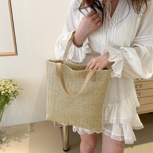 Grand sac cabas en paille tissée avec poignées en cuir marron pour l'été et la plage