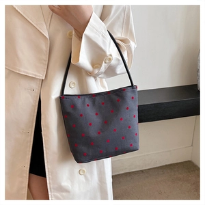 Detailed close-up of dark grey polka dot canvas tote bag with a black shoulder strap