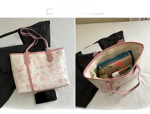 Detail of cream tote bag with pink straps showing interior main compartment and front bear print