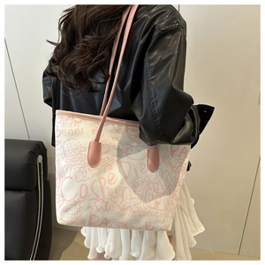 Detail of pink doodle graffiti pattern on creamy canvas tote bag with slim shoulder strap