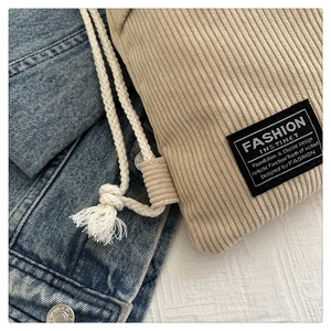 Detailed macro view of beige corduroy fabric texture with a black fashion logo label
