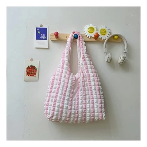 Close-up of pink and white striped seersucker tote bag hanging with stylish accessories