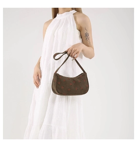 Détail du sac sous le bras en velours marron avec motifs fraises rouges et zip