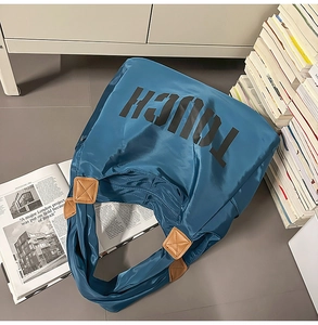 Dettaglio borsa shopper in nylon blu con scritte TOUCH nere e rifiniture in pelle elegante