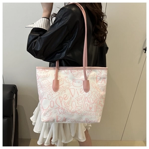 Close-up of a white canvas tote bag with pink graffiti patterns and faux leather straps