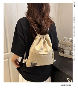 Detailed texture of beige corduroy drawstring backpack with white rope straps