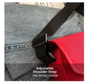 Detail of adjustable black shoulder strap on red oxford crossbody bag showing strap buckle
