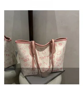 Detail view of canvas tote bag with pink graffiti prints on a white minimalist stool
