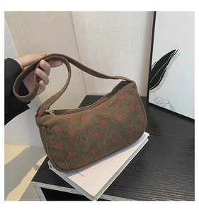 Détail d'un sac sous les bras en velours côtelé marron avec imprimé fraise et zip