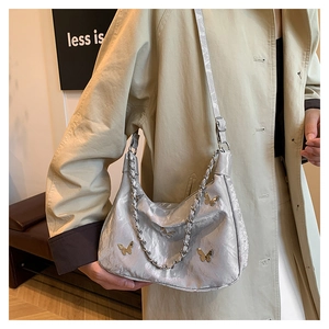 Detail of silver metallic butterfly hobo bag with textured pleats and chain strap