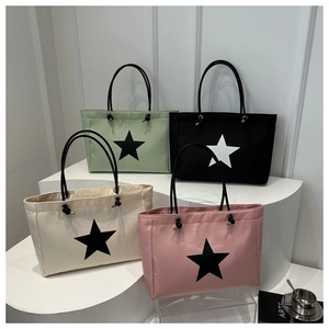 Detail view of the star pattern tote bag in mint, black, beige, and pink colors